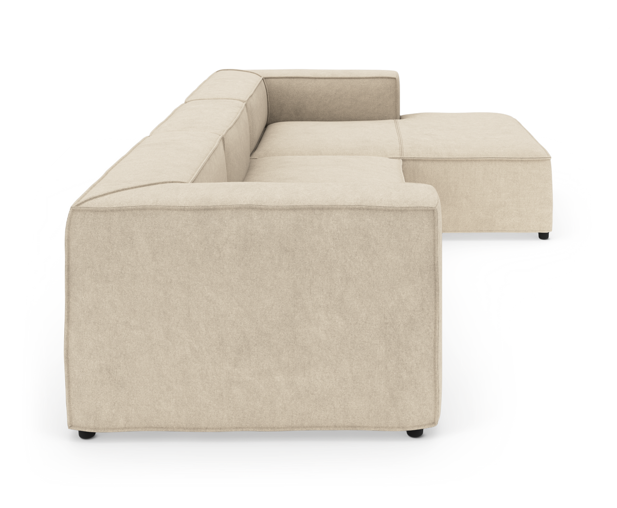 Beige modulsofa i L‑form set fra siden på hvid baggrund.