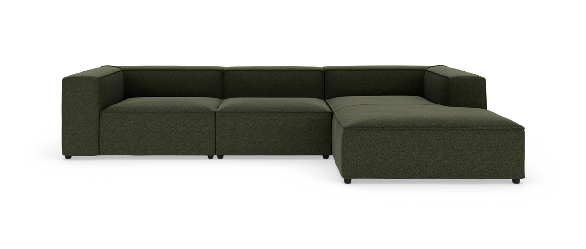 Modulær mørkegrøn hjørnesofa i stof på hvid baggrund.