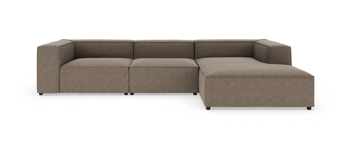 Brun modulsofa med chaiselong til højre, set forfra på hvid baggrund.