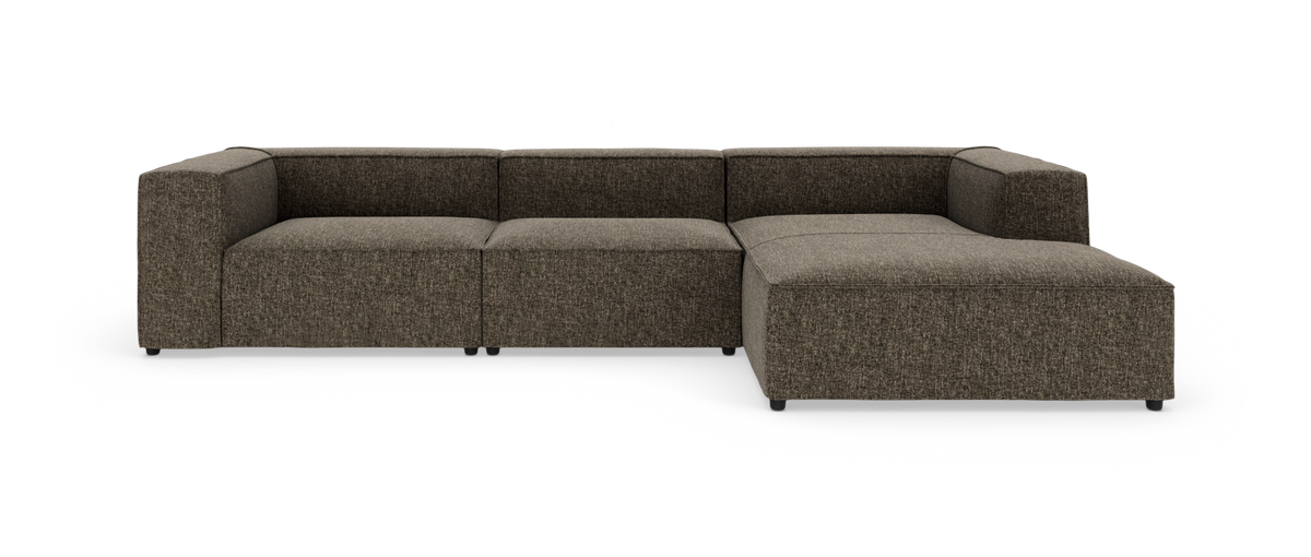 Modulsofa i mørkebrun tekstil med chaiselong til højre, fotograferet forfra i studie.
