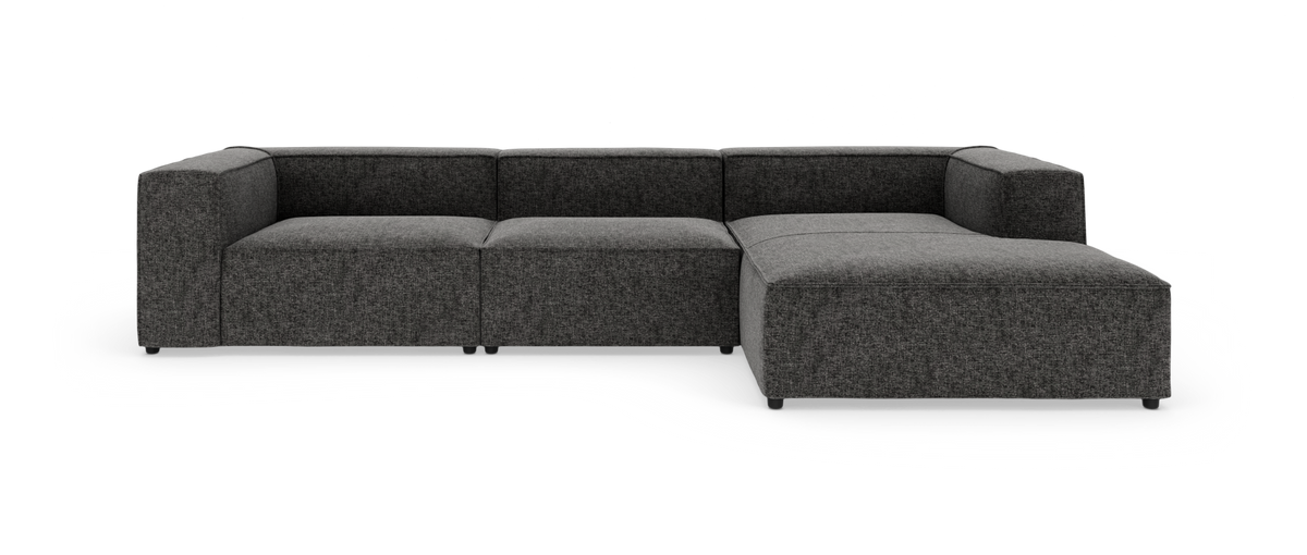 Mørkegrå modulsofa i L-form med chaiselong til højre, vist på hvid baggrund.