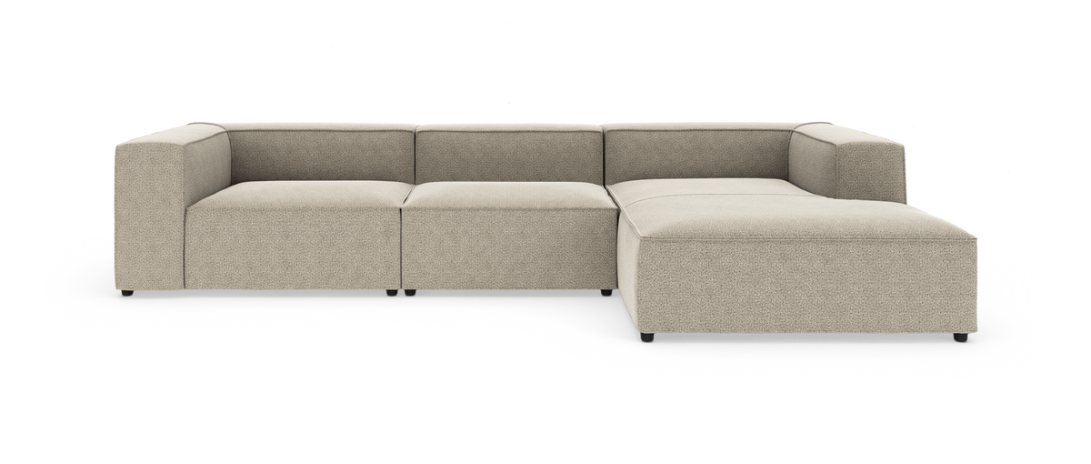 L‑formet modulsofa i beige stof med chaiselong til højre på hvid studiobaggrund.