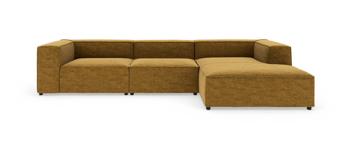 Modulær hjørnesofa i sennepsgul tekstil med chaiselong til højre, fritlagt på hvid baggrund.