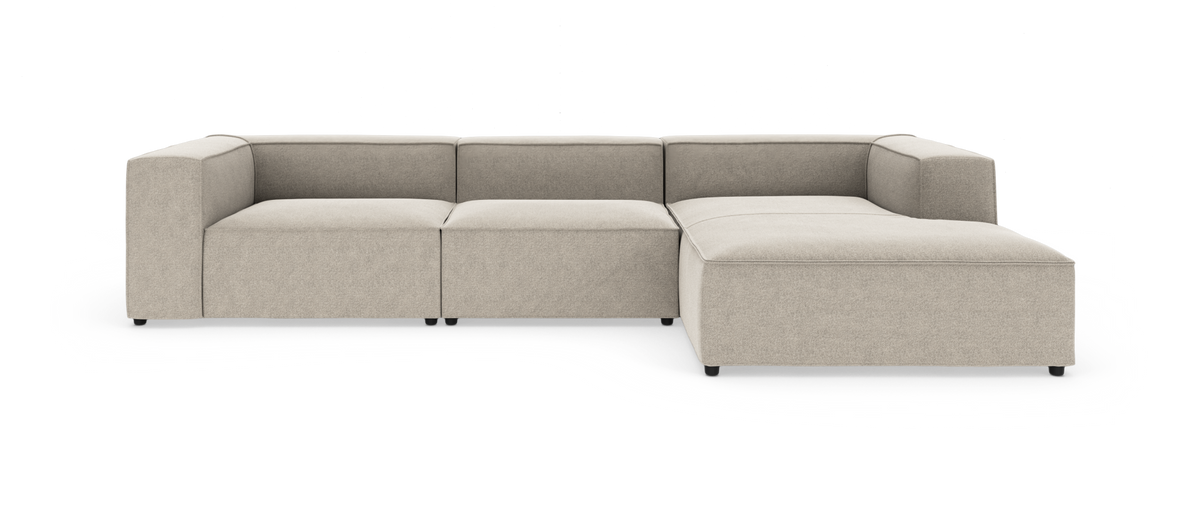 Modulær beige hjørnesofa med chaiselong i højre side, moderne og lav, fritstående på hvid baggrund.