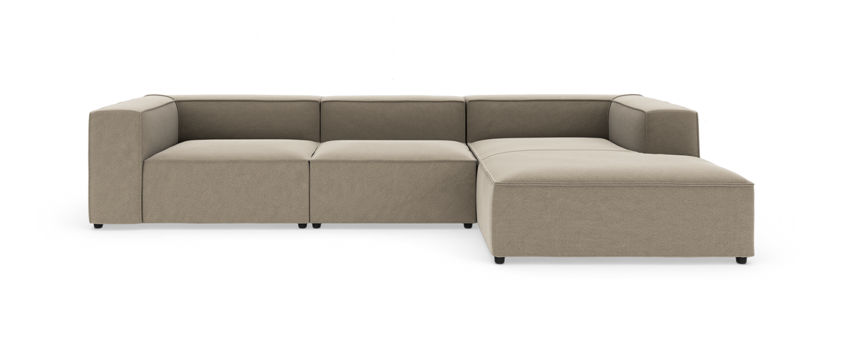 Modulær L‑formet sofa i beige stof med chaiselong til højre, moderne lav profil med kantede armlæn, fritstående på hvid baggrund.