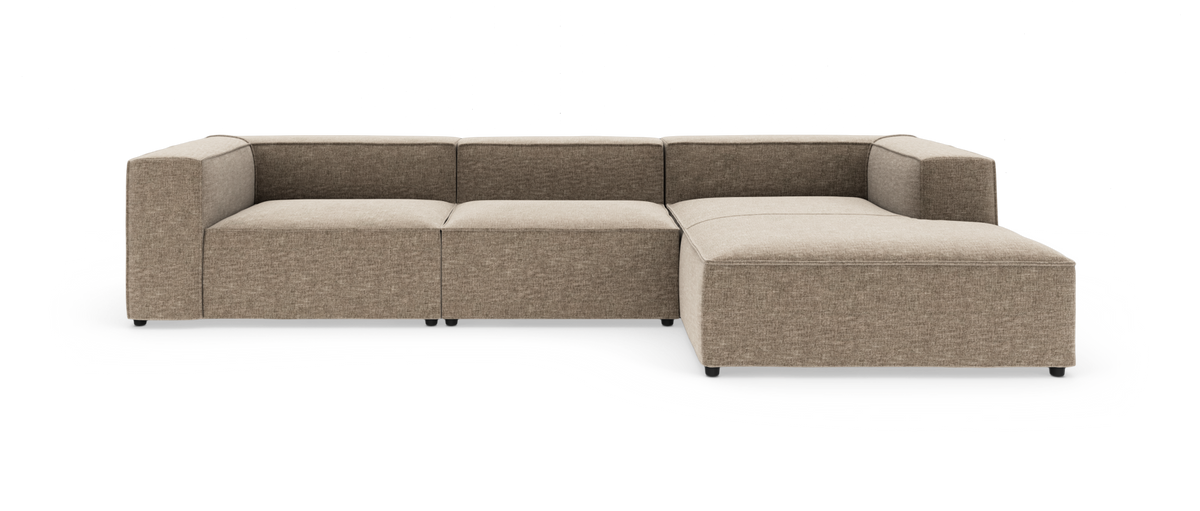 Modulsofa i beige stof, L-form med bred chaiselong til højre på hvid baggrund.