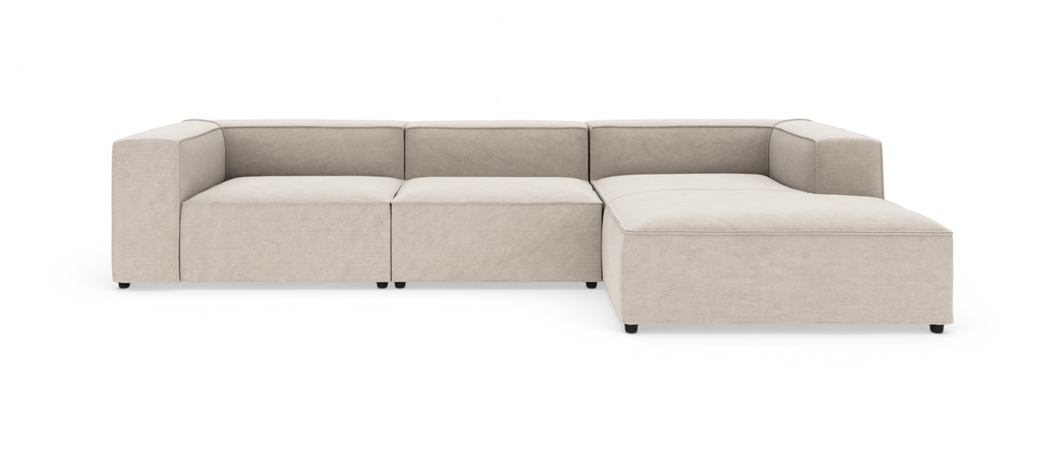 Beige modulsofa i L-form med chaiselong til højre, set forfra på hvid baggrund.