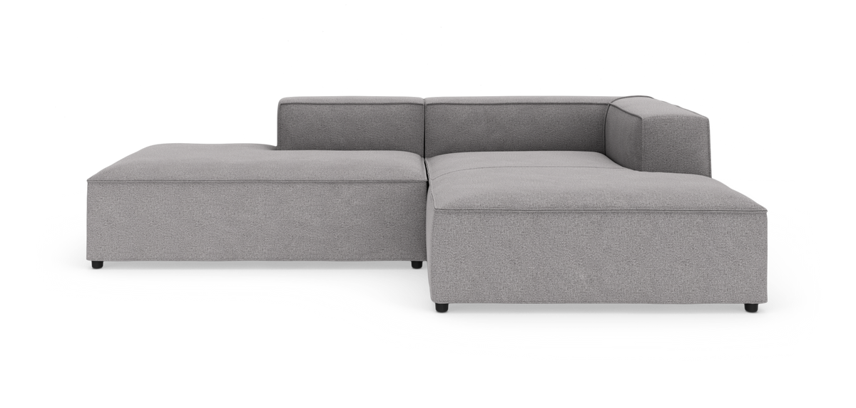 Lys grå modulsofa i L‑form, fotograferet forfra på hvid studiebaggrund.