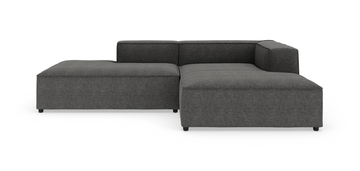 Mørkegrå modulhjørnesofa med chaiselong til venstre, lave ryg- og armlæn, på hvid studiebaggrund.