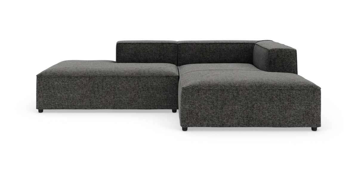 Mørkegrå modulsofa i L-form med lav ryg og bred chaiselong.
