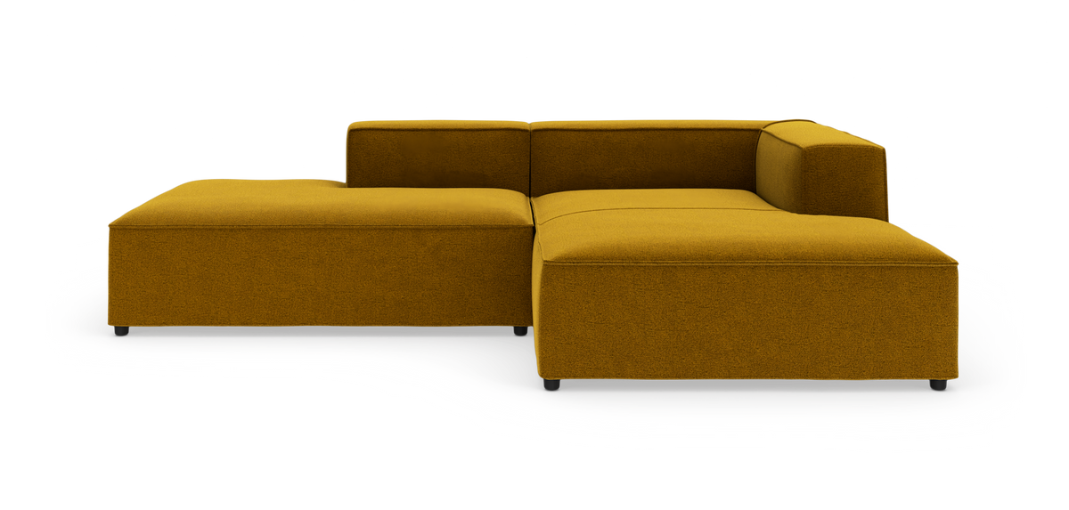 Modulsofa i sennepsgult stof i L‑form med lav ryg, vist på hvid studiobaggrund.