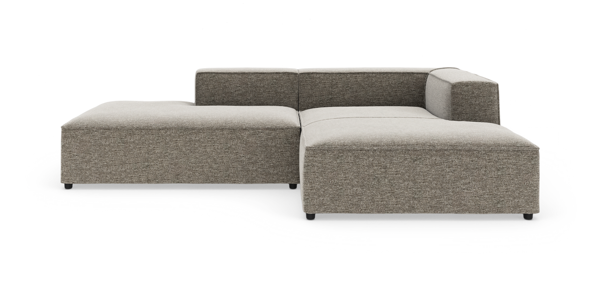 Modulær hjørnesofa i grå‑beige stof på hvid studiebaggrund.
