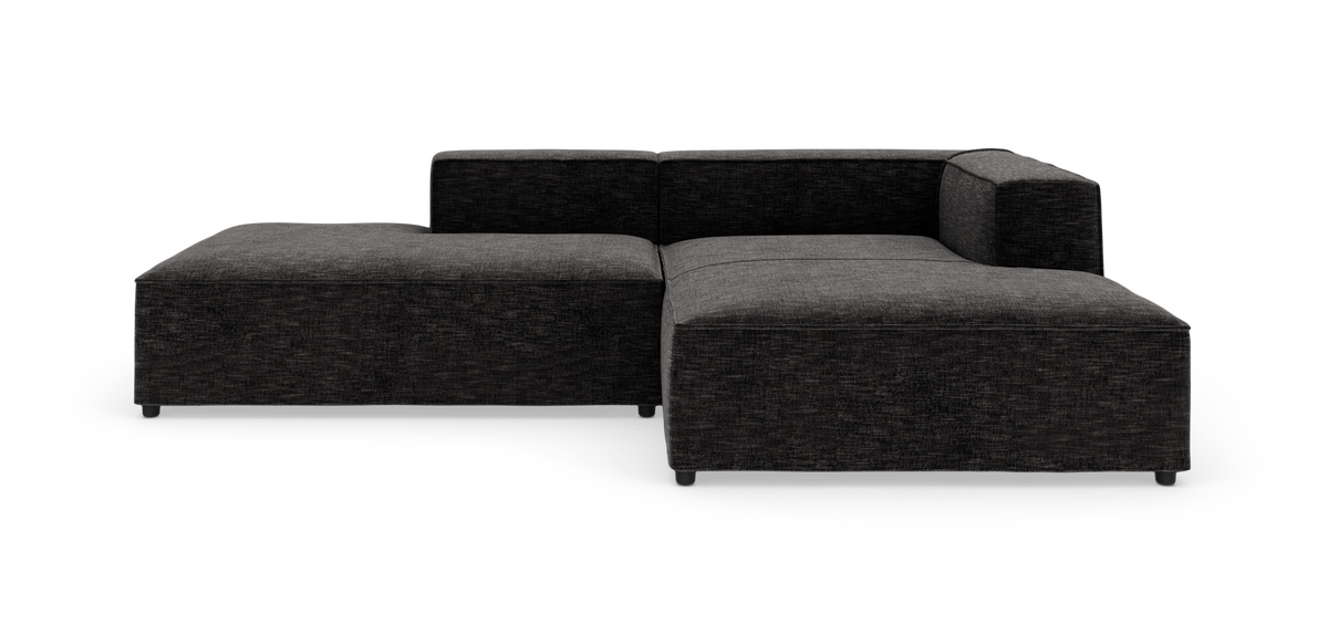 Mørkegrå modulsofa i L‑form på hvid baggrund.