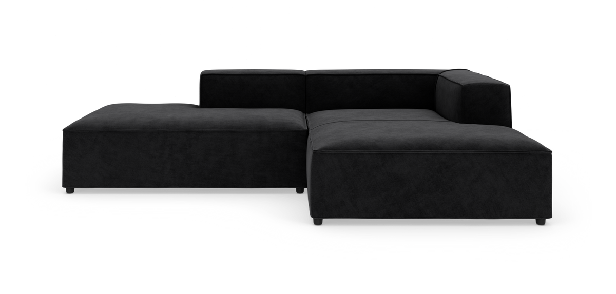 Sort modulsofa i L-form med bred chaiselong, fritlagt på hvid baggrund.