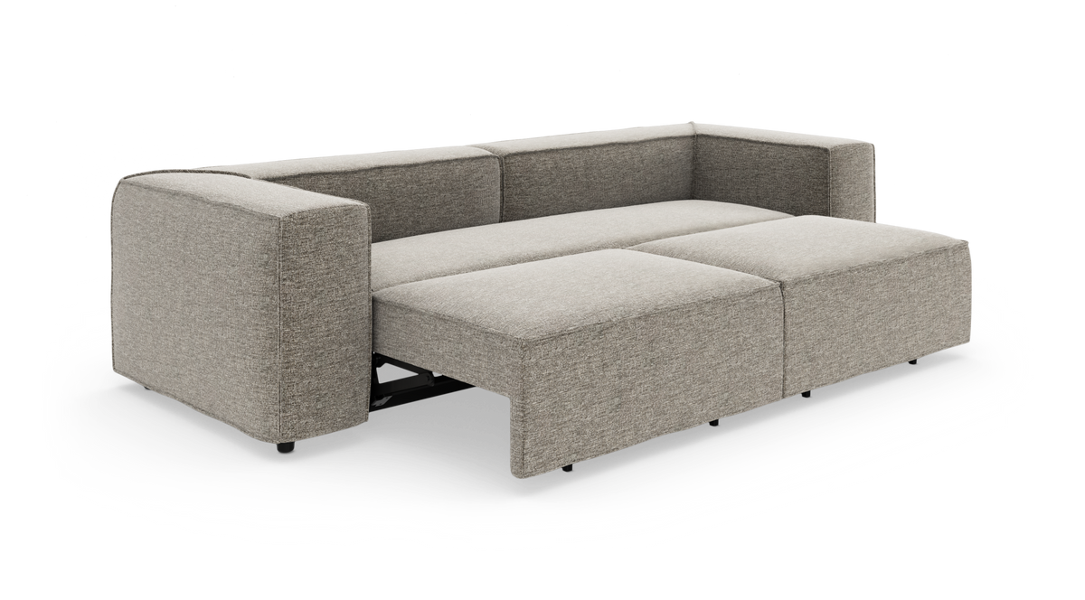Beige modulsofa som sovesofa, slået ud til en stor liggeflade i studieopsætning.
