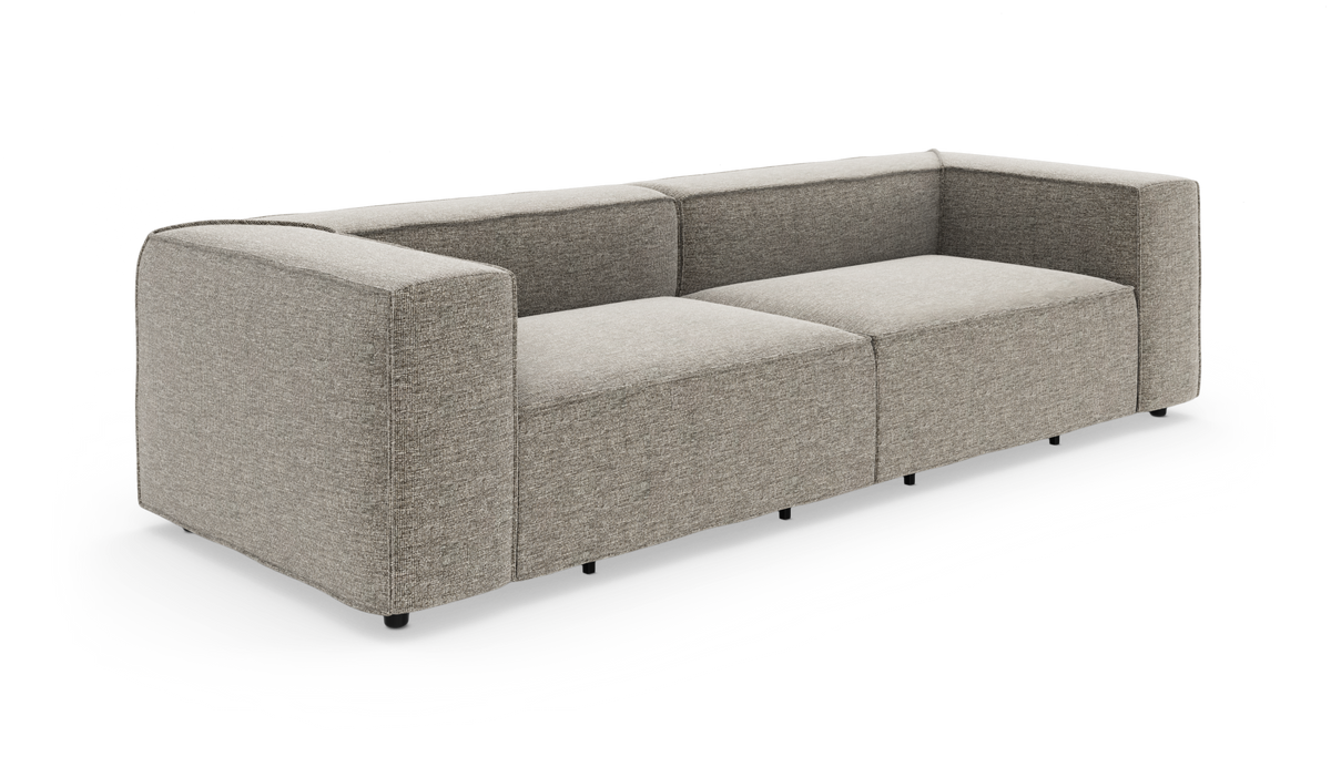 Modulær tresæders sofa i lysegråt stof med brede armlæn og lav ryg, vist i vinkel på hvid baggrund.