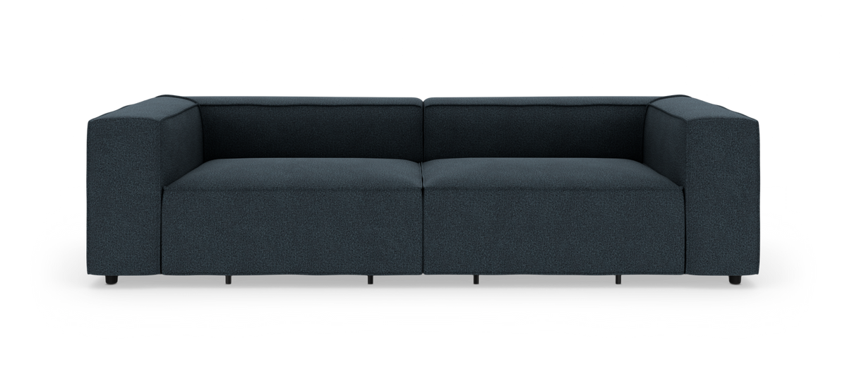 Mørkeblå, lav modulsofa i moderne, boxet design frilagt på hvid baggrund, set lige forfra.