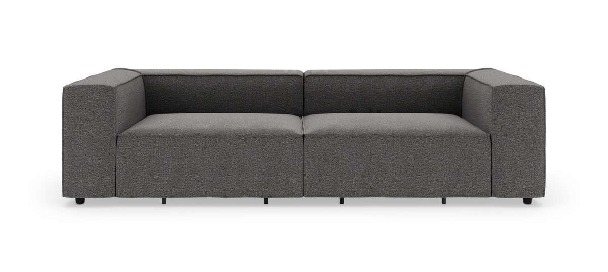 Mørkegrå modulsofa med kraftige, boxede armlæn og lav ryg, frilagt på hvid baggrund.