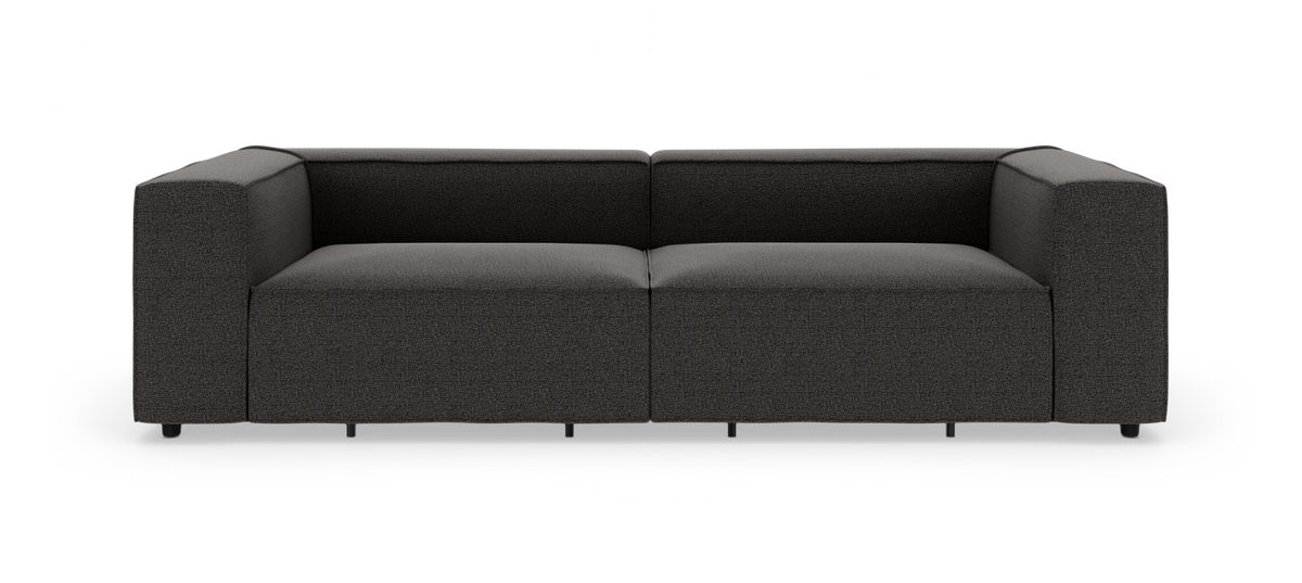 Mørkegrå moderne lav modulsofa med brede armlæn og dybt sæde, frilagt på hvid baggrund, set lige forfra.