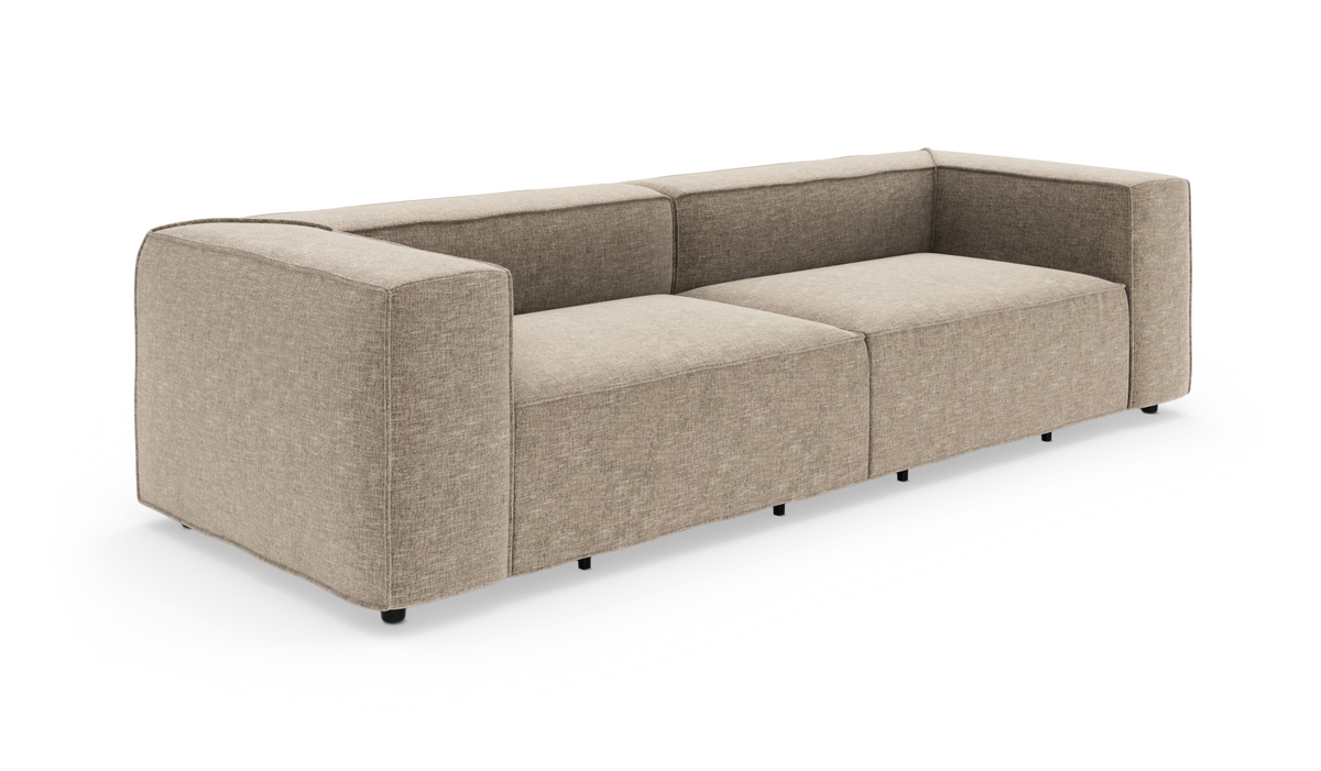 Beige modulsofa med brede armlæn og lave sorte ben, frilagt på hvid baggrund.