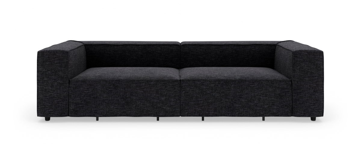 Mørkegrå modulsofa med brede armlæn, fotograferet forfra i studie på hvid baggrund.