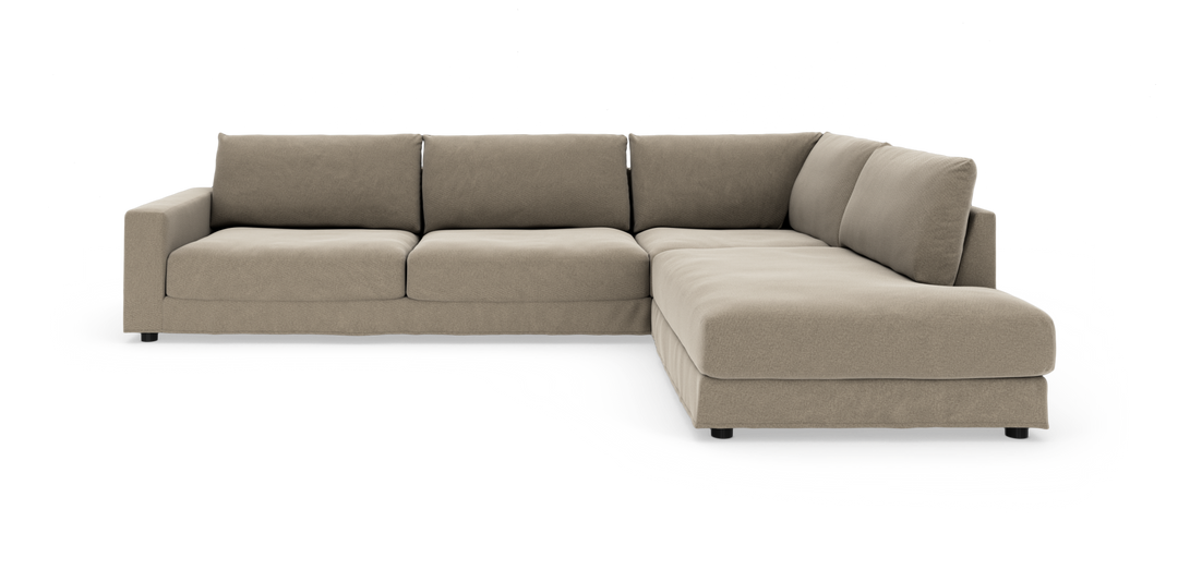 Beige L-formet modulsofa med brede puder og lav profil, vist på hvid baggrund.