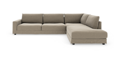 Beige L-formet modulsofa med brede puder og lav profil, vist på hvid baggrund.