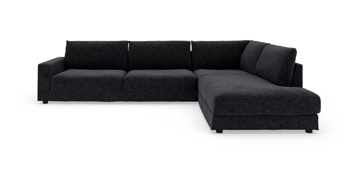 Mørkegrå L‑formet modulsofa med chaiselong til højre, fotograferet i studie.