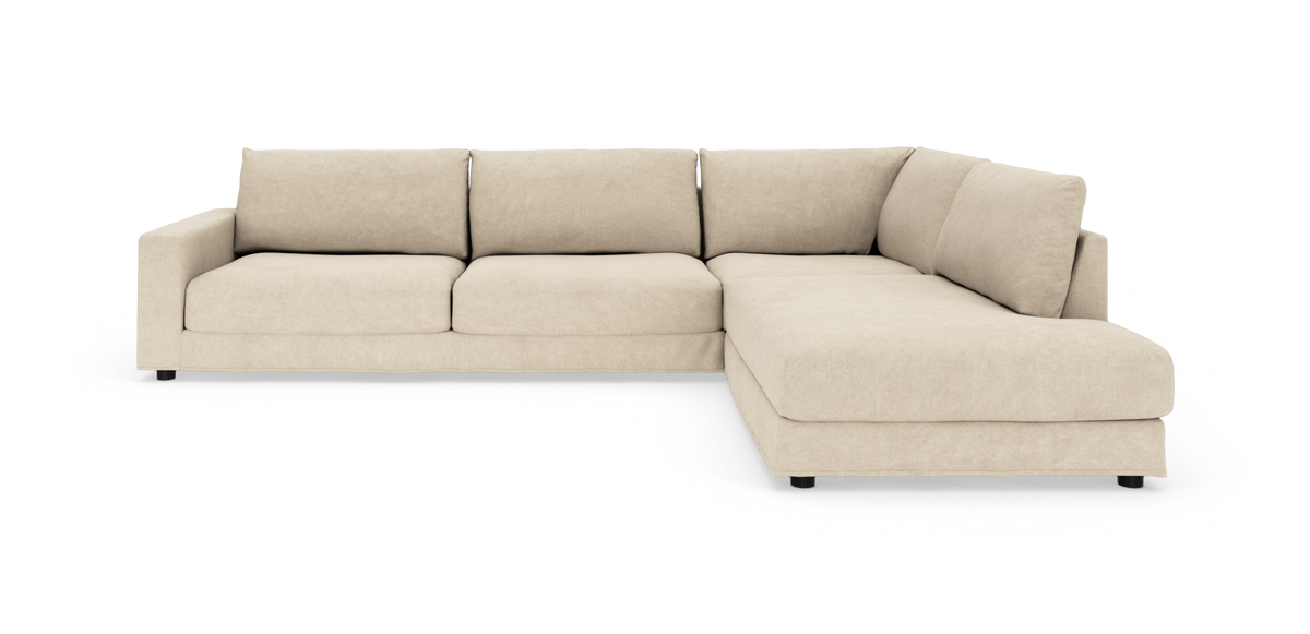 Beige modulsofa i L-form med chaiselong til højre på hvid baggrund.