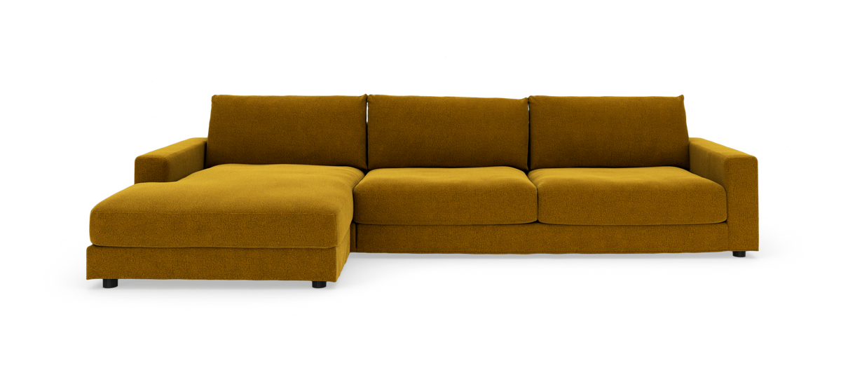 Modulsofa i sennepsgul tekstil med venstrevendt chaiselong, frilagt mod hvid baggrund.