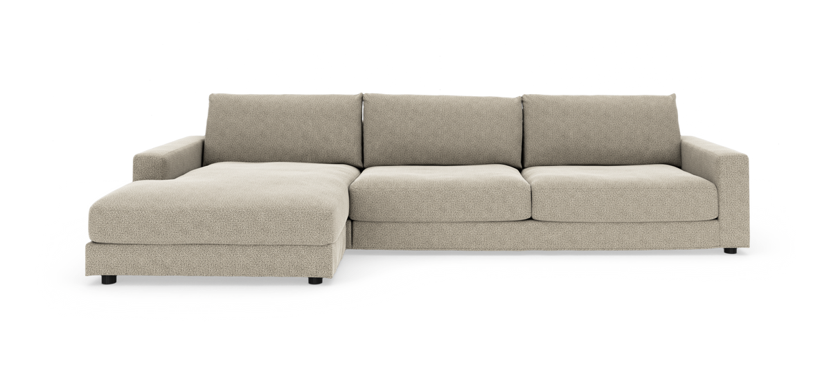 Beige hjørnesofa med venstrevendt chaiselong i blødt stof på hvid baggrund.