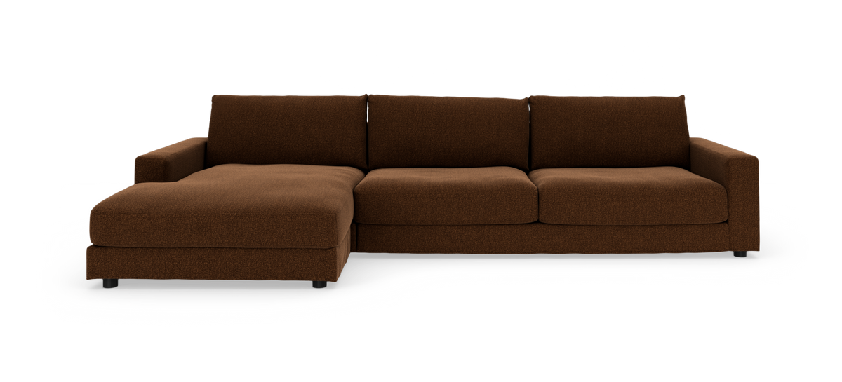 Brun modulsofa med chaiselong i venstre side, lav profil og kraftige hynder, frilagt på hvid baggrund.