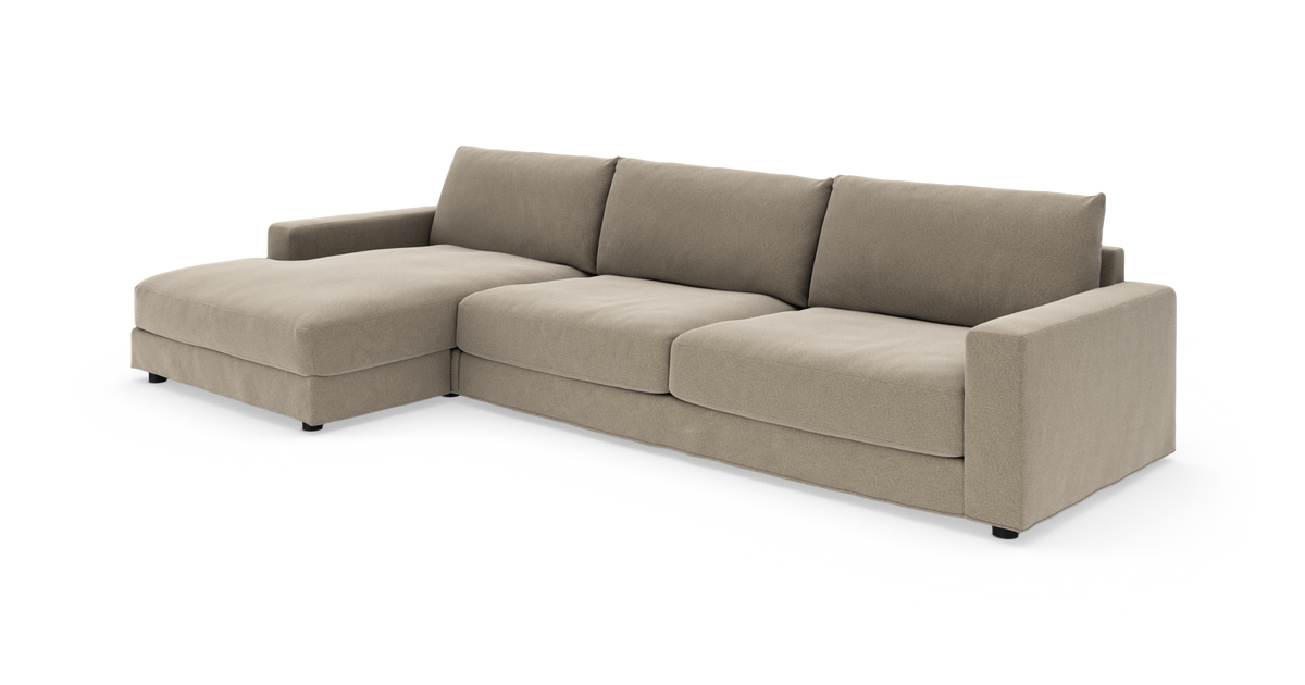 Beige hjørnesofa med venstre chaiselong og tre sædehynder, lave lige armlæn, frilagt på hvid baggrund.