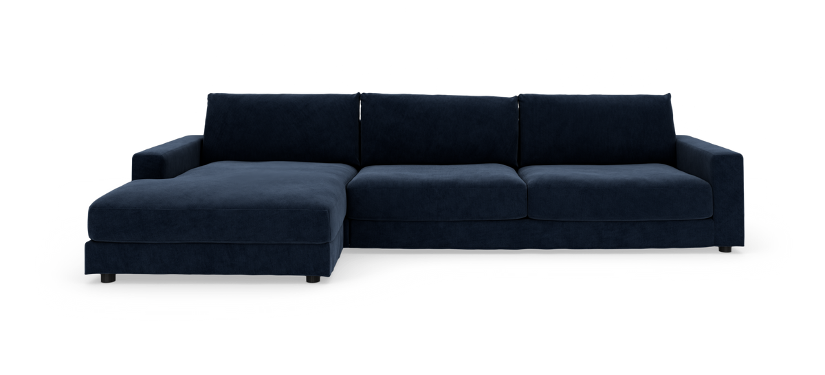 Mørkeblå hjørnesofa med chaiselong til venstre, bred lav profil på hvid baggrund.