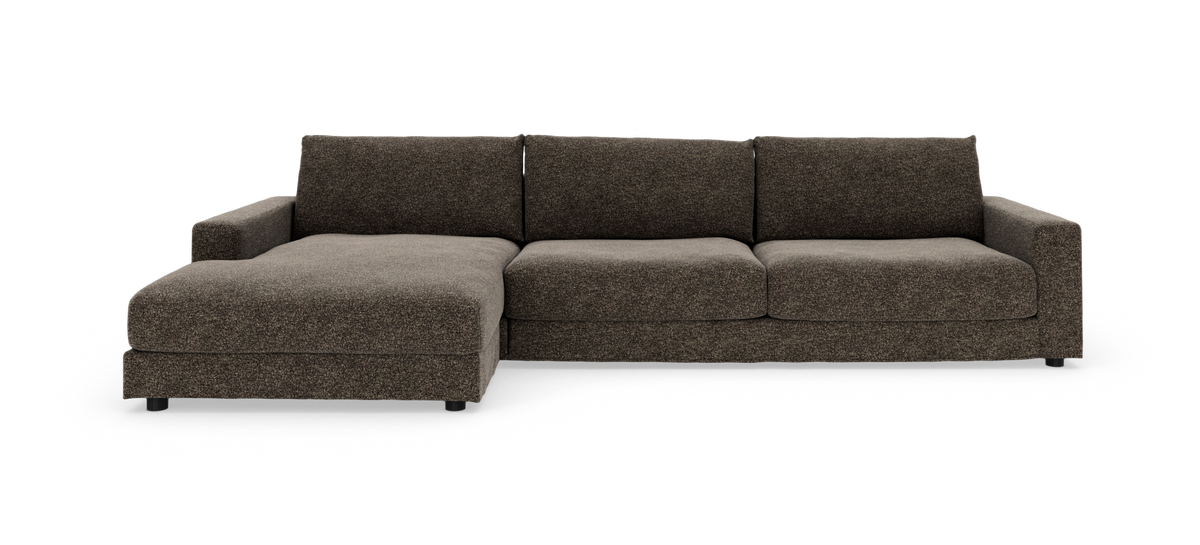 Mørkebrun hjørnesofa med venstrevendt chaiselong, tre ryghynder og brede armlæn.