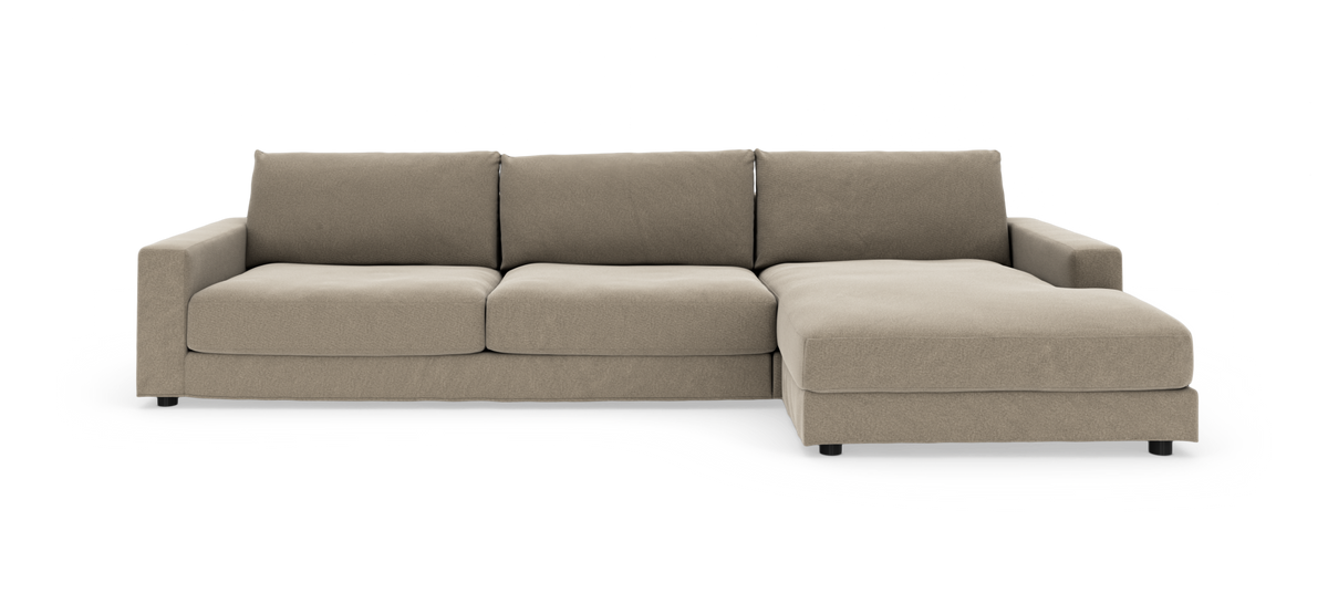 Beige hjørnesofa med chaiselong på højre side, lave lige armlæn og tre sædehynder, frontvisning isoleret på hvid baggrund.