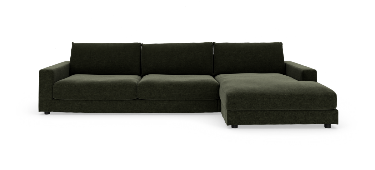 Mørkegrøn modulsofa med chaiselong til højre, fotograferet forfra på hvid baggrund.