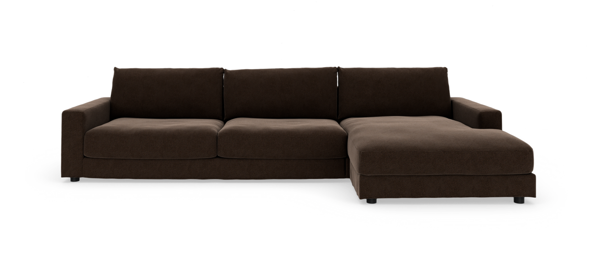 Brun hjørnesofa med chaiselong til højre, lav profil og lige armlæn.
