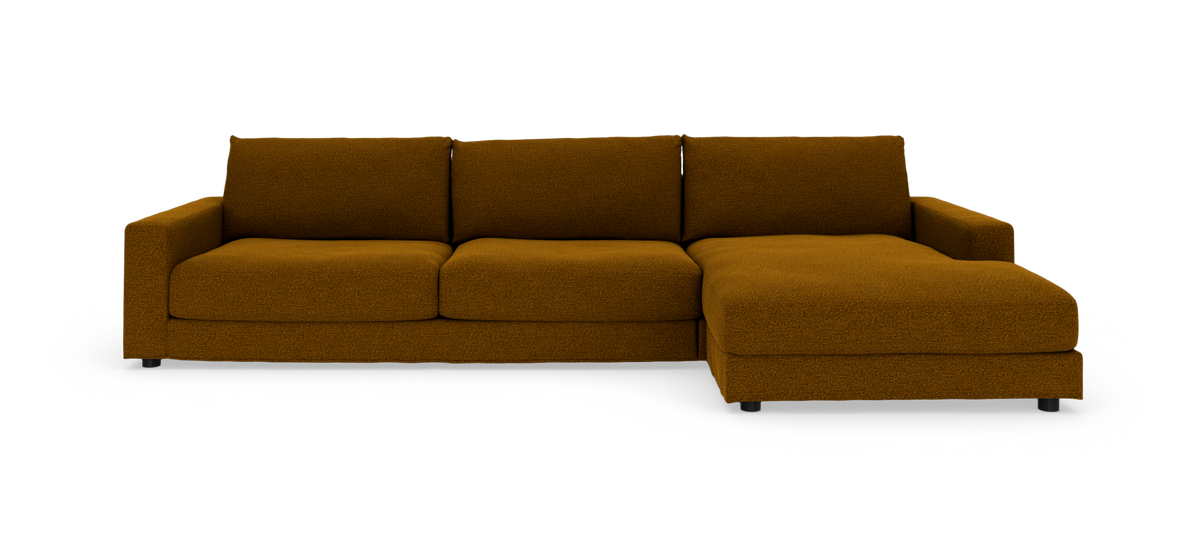 Brun modulsofa med chaiselong til højre, tre sædehynder og lave armlæn, vist i studie mod hvid baggrund.