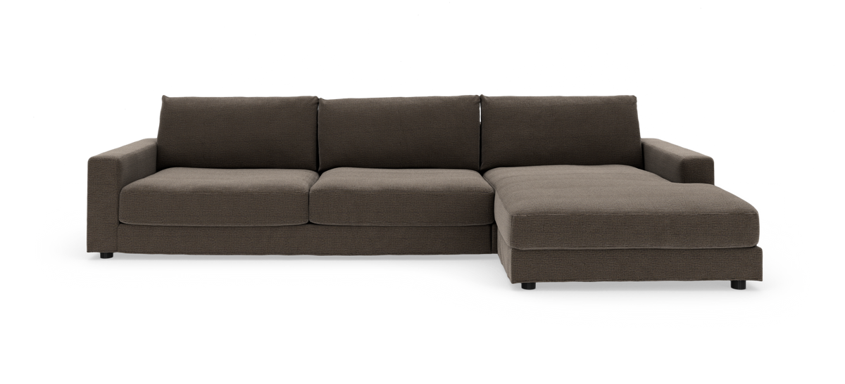 Mørkebrun modulsofa med chaiselong til højre på hvid baggrund.
