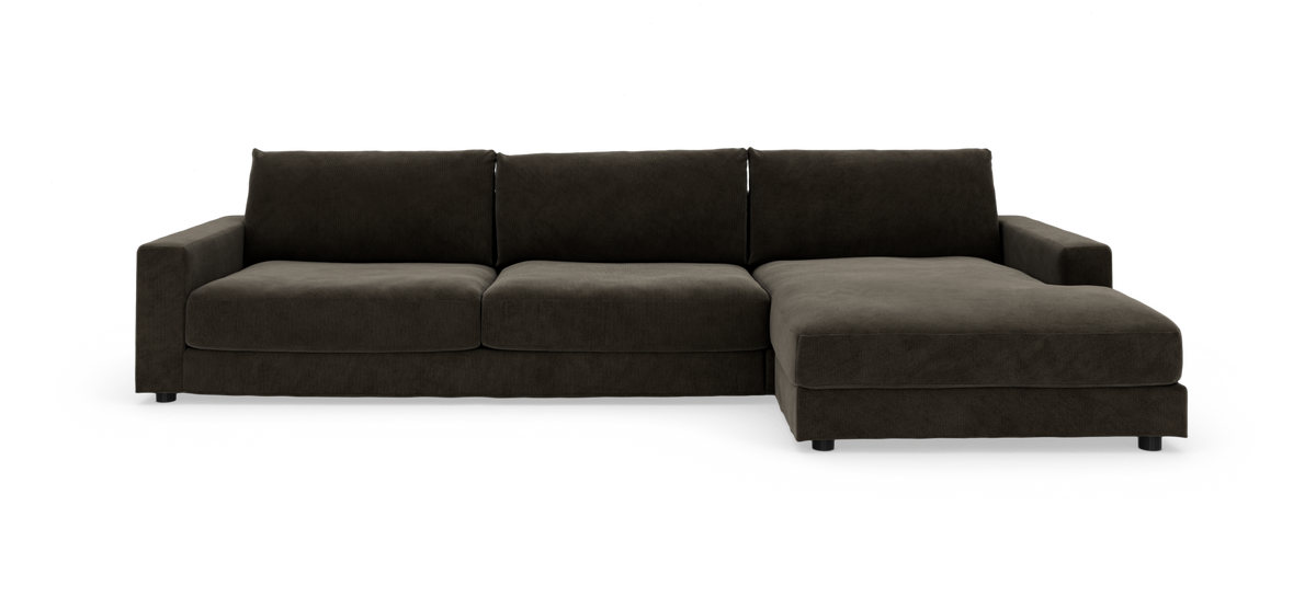 Mørkebrun hjørnesofa med chaiselong til højre, set forfra på hvid baggrund.