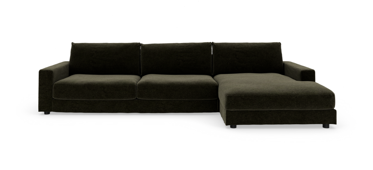 Mørkegrøn modulsofa med chaiselong til højre, set forfra mod hvid baggrund.