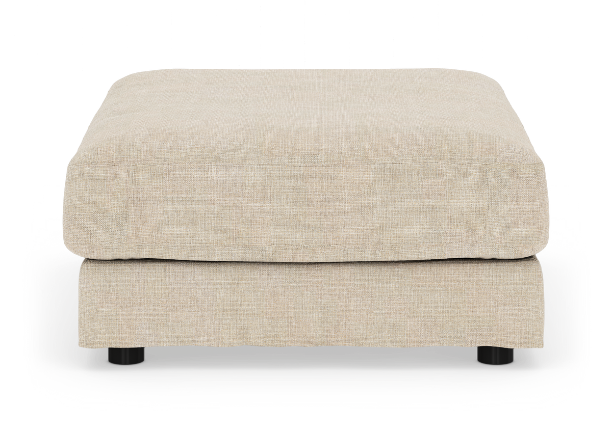 Beige puf i stof med blød, kvadratisk form på hvid baggrund.