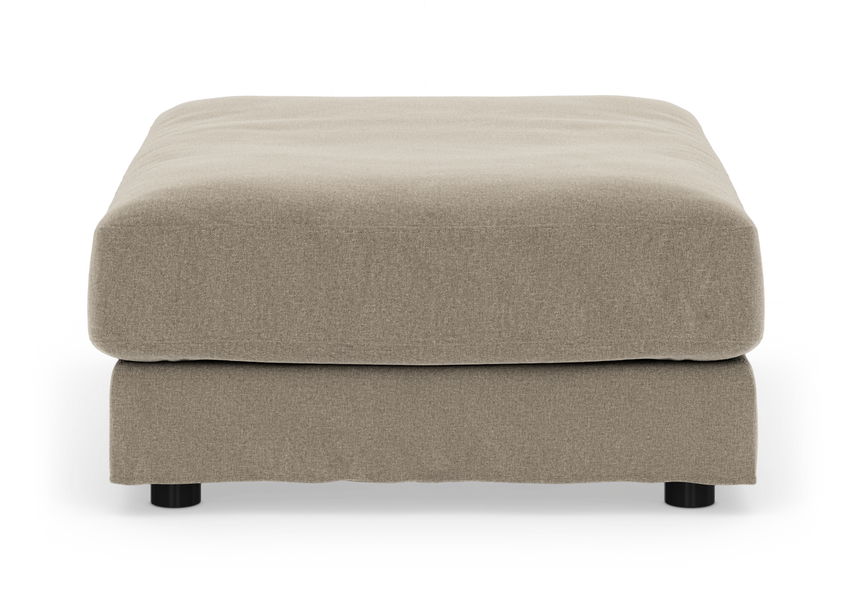 Beige polstret puf med stofskørt og lave sorte ben, set forfra mod hvid baggrund.