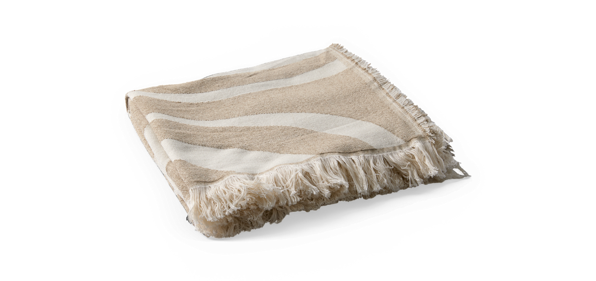 Beige og hvid plaid med bølgede striber og frynser, sammenfoldet.