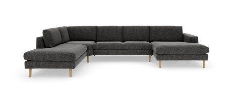 U‑formet modulsofa i mørkegråt stof med chaiselonger i begge ender og lyse træben, frilagt i studielys.
