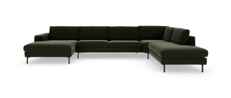 Mørkegrøn modulær L‑formet hjørnesofa med chaiselong til venstre og bred divan til højre på slanke sorte ben, fritlagt på hvid baggrund.