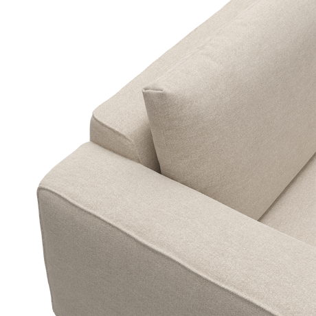 Nærbillede af beige stofsofa med armlæn og ryghynde.