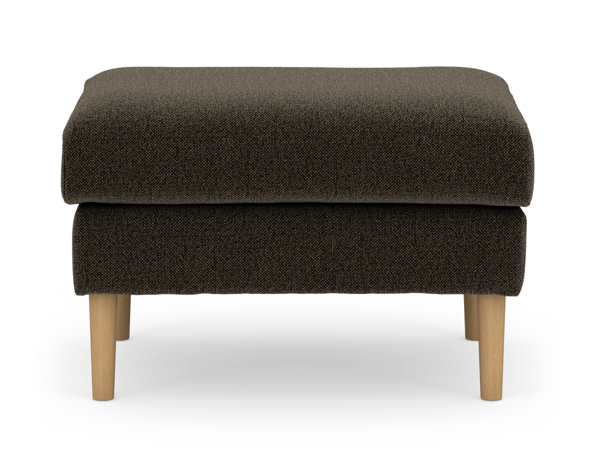 Mørkebrun stofbeklædt pouf med lyse træben, fotograferet forfra i studie på hvid baggrund.