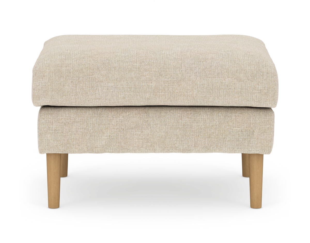 Beige stofpuf/ottoman med lyse træben, frilagt på hvid baggrund.